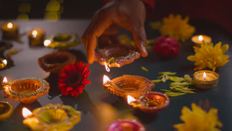Primer-Plano-De-Un-Hombre-Encendiendo-Lámparas-De-Aceite-Diya-Celebrando-El-Festival-De-Diwali